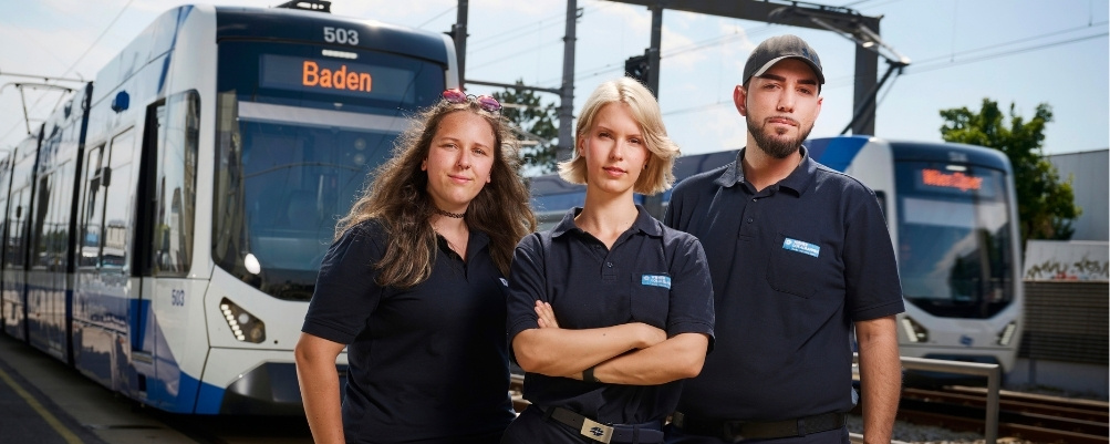 Drei Personen stehen vor der Badner Bahn